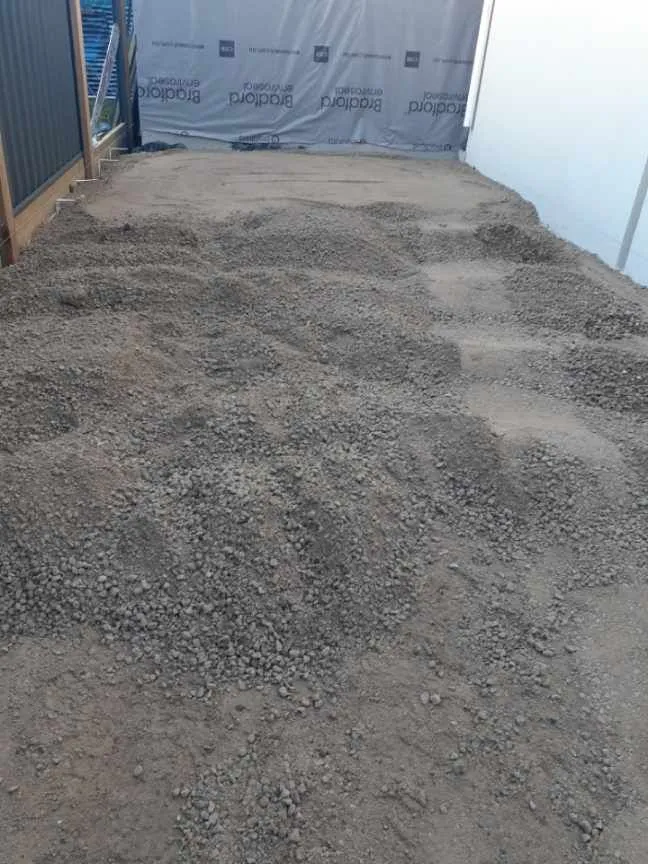 Crushed rock base spread and levelled beside the house before the pour